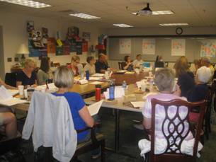 Nebraska educators from across the state surrounded by memory boxes timelines and insptirational materials