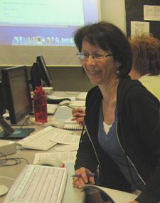 Teacher smiling from her seat at the computer