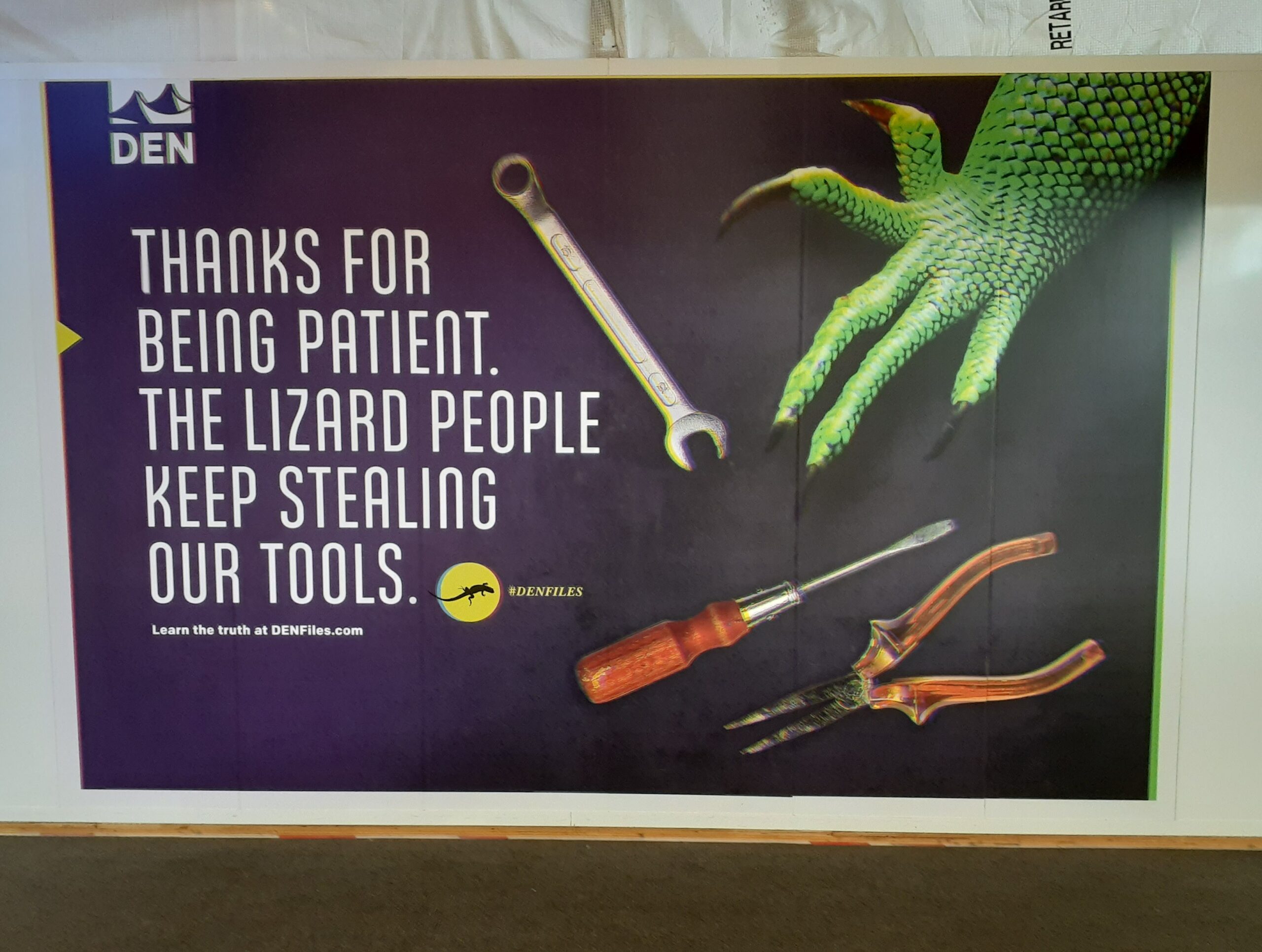 a wrench screwdriver and pliers are on the floor and a lizard hand is grabbing at them. Text reads "thanks for the patience the lizard people keep stealing our tools." #DENFILES