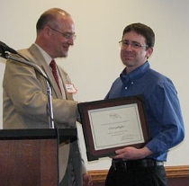 Robert Brooke presenting Chris Gallagher with his certificate