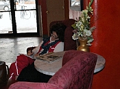 Woman writing in a burgundy chair