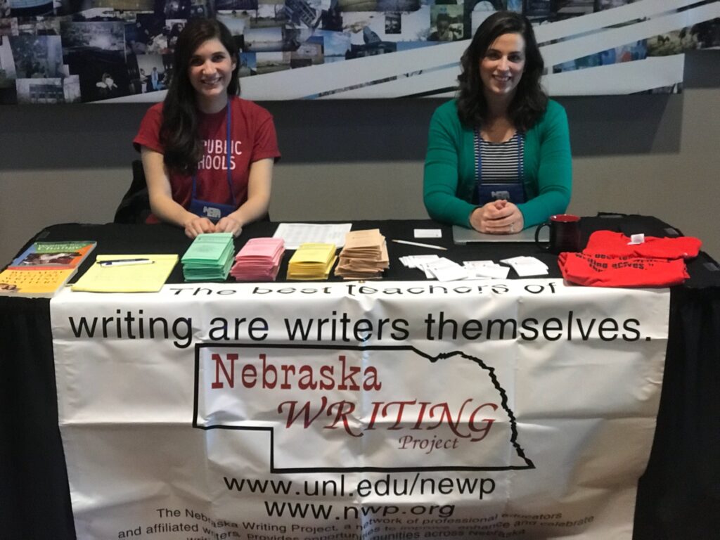 Melissa Legate and Jennifer Troester sitting at the NeWP table during NETA