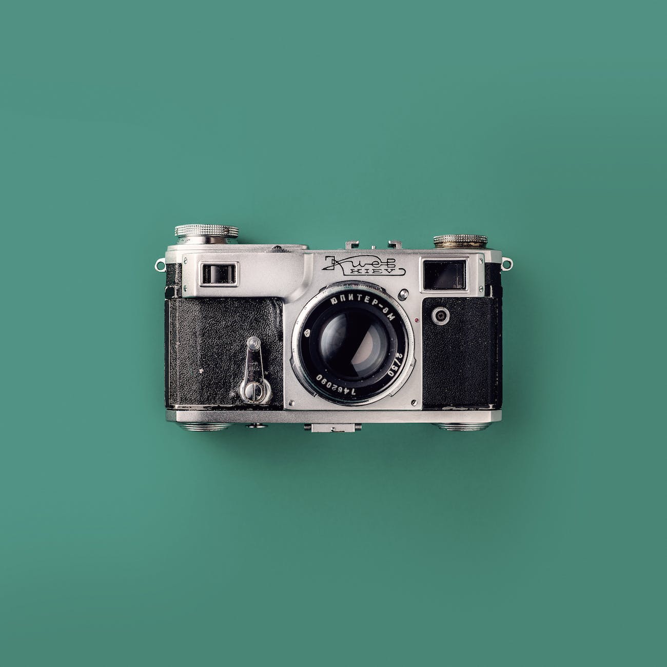 grey and black camera on green background